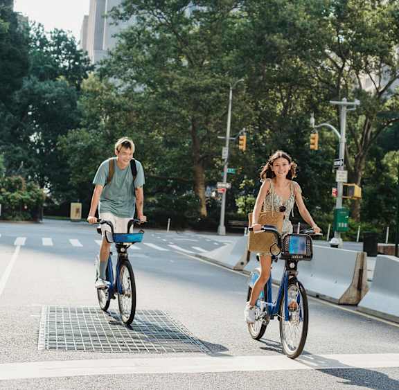 A man and a woman are riding bicycles on a city street.
