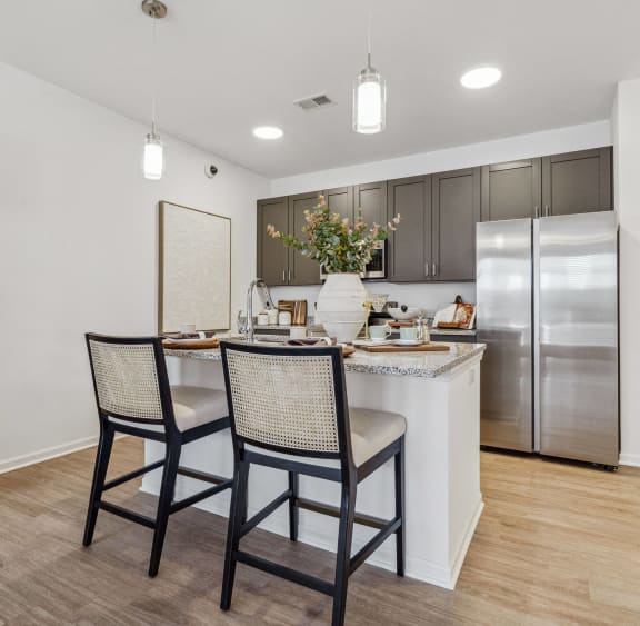 a kitchen with stainless steel appliances and brown cabinets at Plat 4 at Research Triangle in Durham, NC
