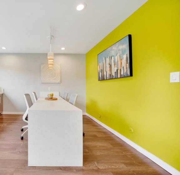 a dining room with a table and chairs and a yellow wall at Sunset Square, West Covina, CA