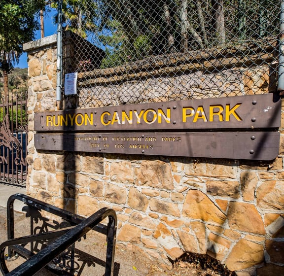 a sign for run on canyon park on a stone wall next to a gate