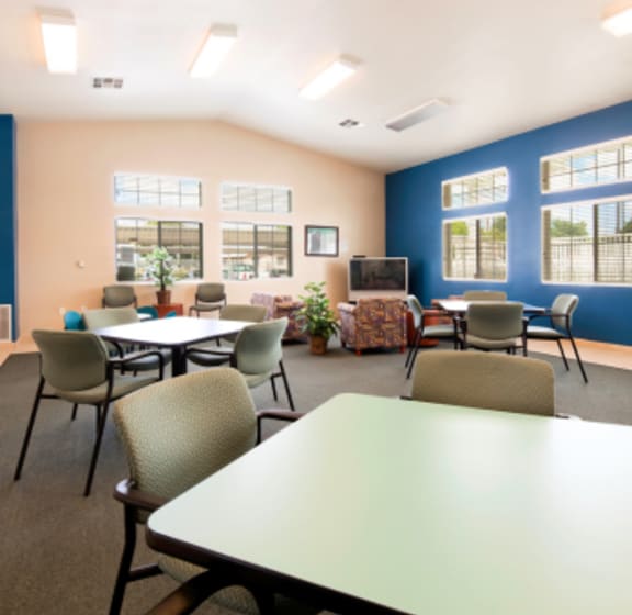 a room with tables chairs and a television