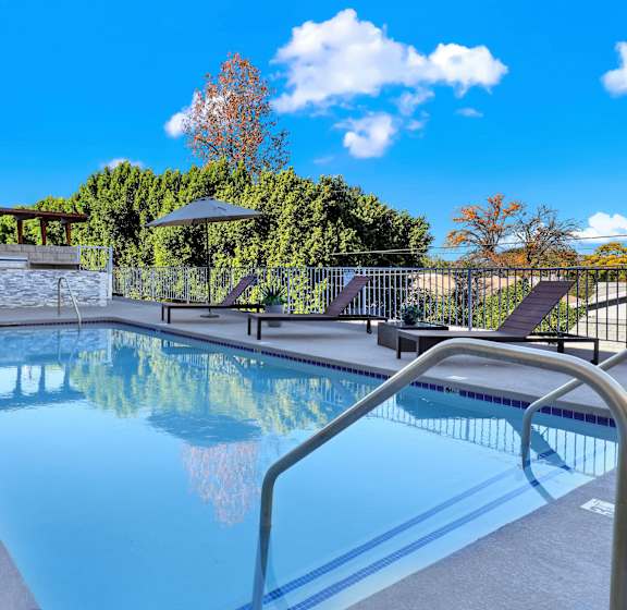 A swimming pool with a metal railing and a building in the background.