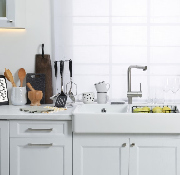 a white kitchen with a sink and a window