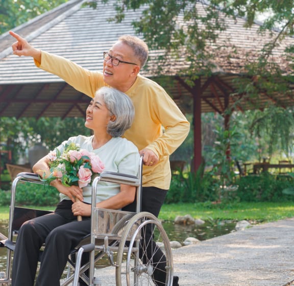 a man pushing a woman in a wheelchair