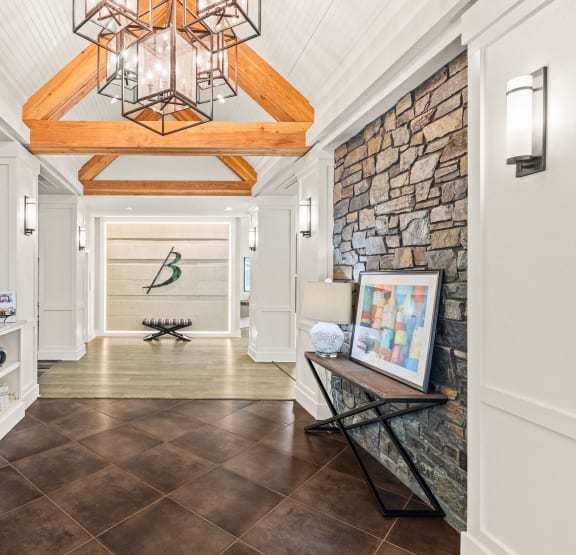a long hallway with a stone wall and a vaulted ceiling with a light fixture