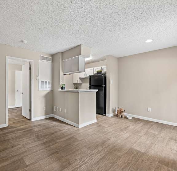A kitchen area with a refrigerator, microwave, and cabinets.
