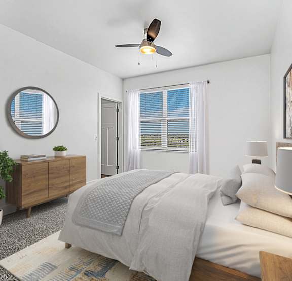 A living room with a ceiling fan, beige couch and coffee table at Andover Pointe Apartment Homes, LA Vista, NE