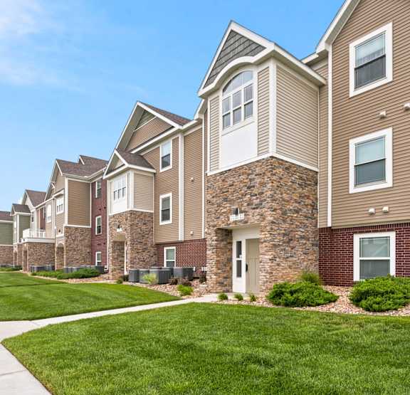 Exterior apartment building with landscaping at Copper Creek Apartment Homes in Maize, KS