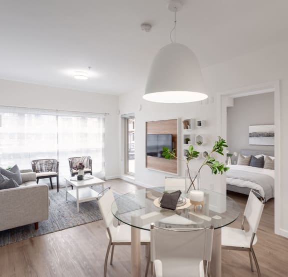a living room and dining area with a glass table and chairs