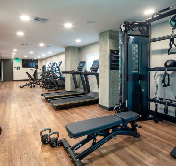 a large fitness room with cardio machines and weights  at VORA LUX, San Diego