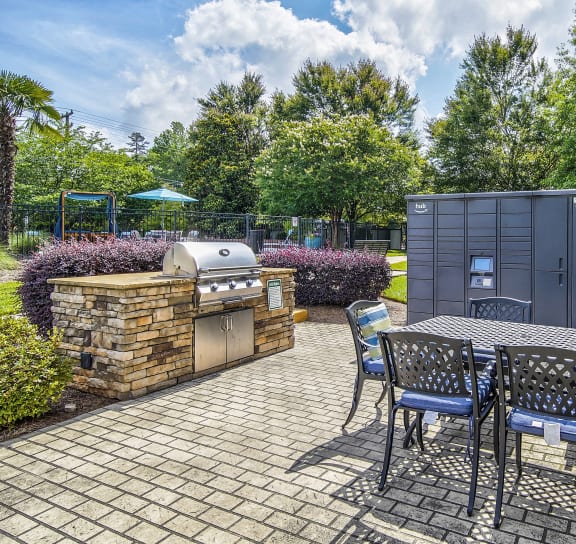 a patio with a table and chairs and a barbecue grill