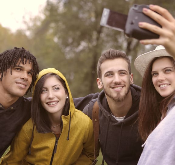 a group of friends taking a picture with a cell phone