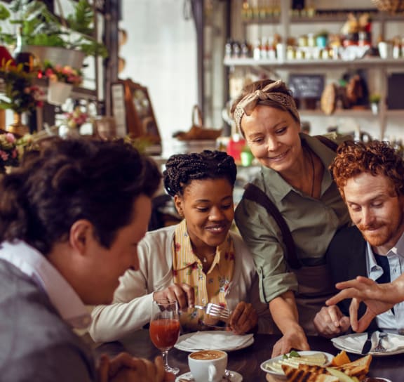 A group of people are gathered around a table in a restaurant at The Reserve at Sugarloaf Apartments, Duluth, GA, 30097