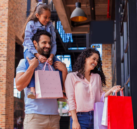 a family walking out of a store with shopping bags