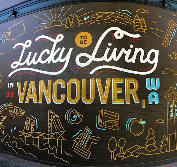 the front of a mall with people walking into the building at AVIA Lofts on Parkway Apartments, Vancouver, 98662