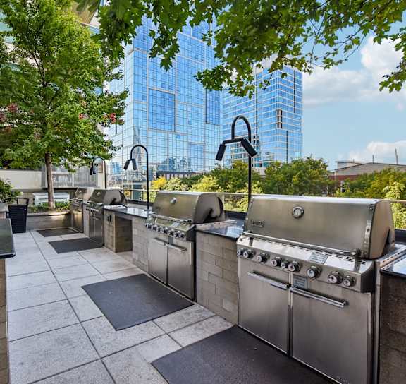 A patio with tables and chairs is surrounded by buildings.