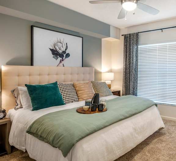 A bedroom with a bed, nightstand, and window.
