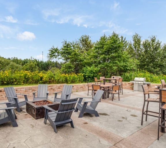 a patio with chairs and tables and a fire pit at Campus Park, Duluth, MN, 55811