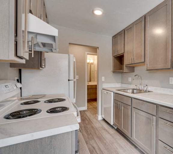 A kitchen with a white stove top oven and a white counter top.