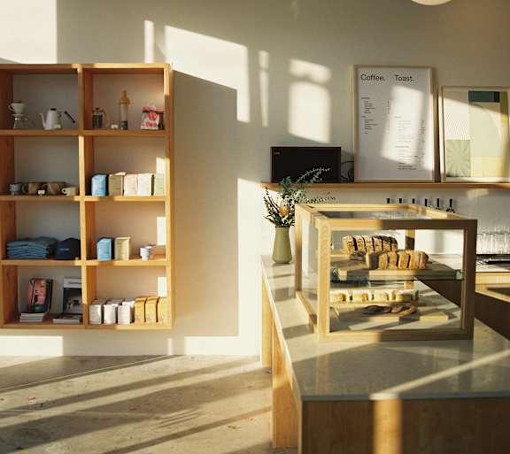 A room with a shelf and a table with a plant on it.