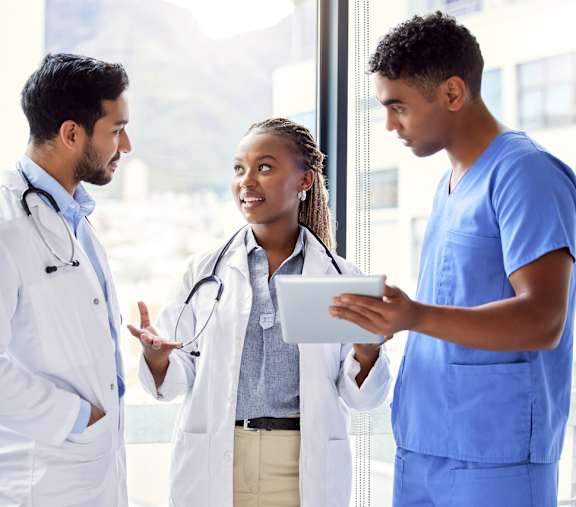 Three medical professionals in a discussion in a brightly lit room.at Park Lamont Apartments & Townhomes, Ohio