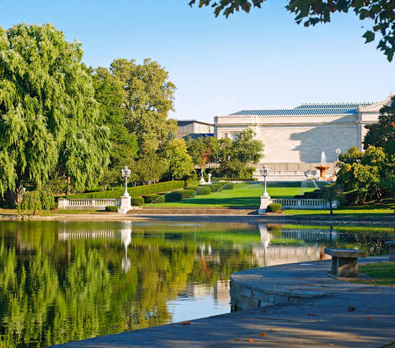 A serene park with a pond, a statue, and a building in the background.at Park Lamont Apartments & Townhomes, Ohio