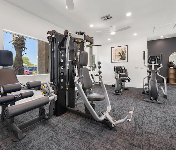A spacious gym with a variety of equipment including treadmills, elliptical machines, and weights.