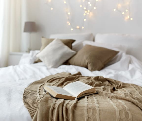 a bed with an open book on top of it