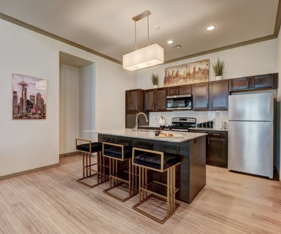 a kitchen with stainless steel appliances and a large island with stools