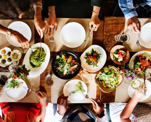 a group of people sitting at a table eating food