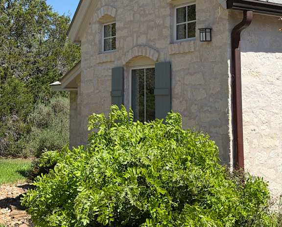 A house with a stone facade and a metal roof.