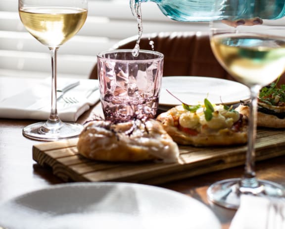 a table with a plate of food and a glass of wine