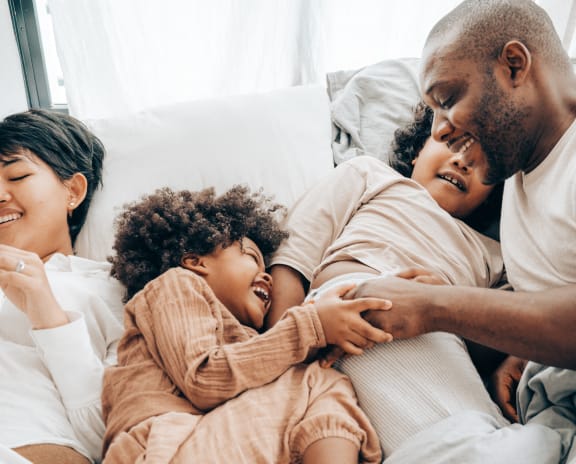 a family of three is laying in bed together