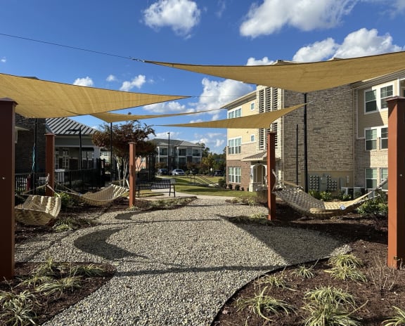 a courtyard with hammocks and umbrellas in an apartment building