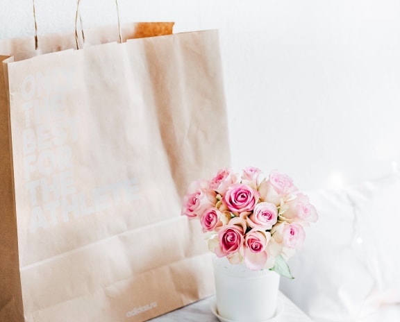 Brown shopping bag near flowers