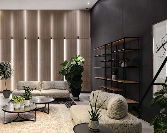 A living room with a green chair and a white sofa.at Baseline Apartments, Ottawa, ON