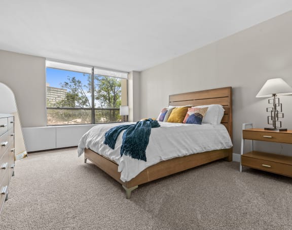 a bedroom with a bed and a large window