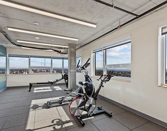A room with a treadmill and a stationary bike.