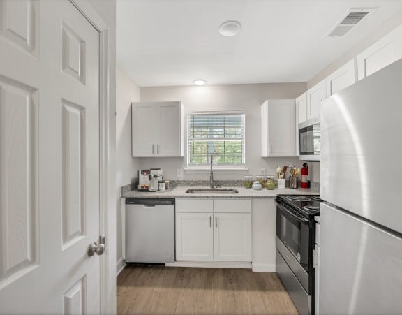 a white kitchen with white cabinets and black appliances