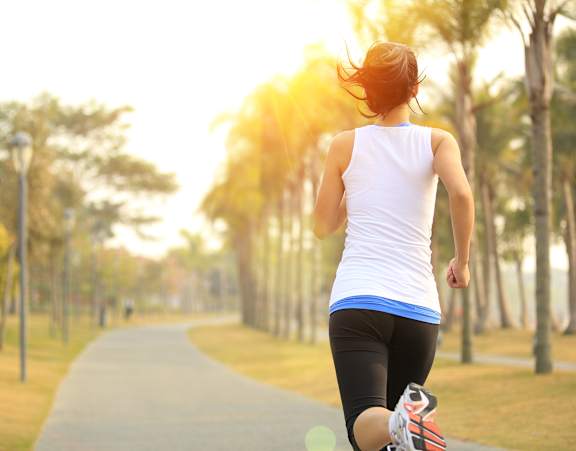 A woman running on a path in a park.