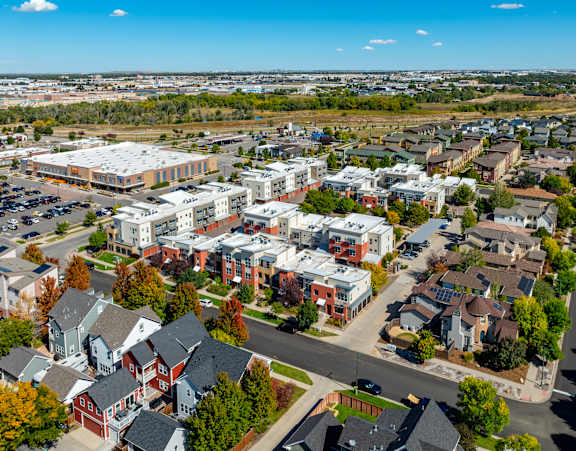 A bird's eye view of a residential area with houses and a parking lot.