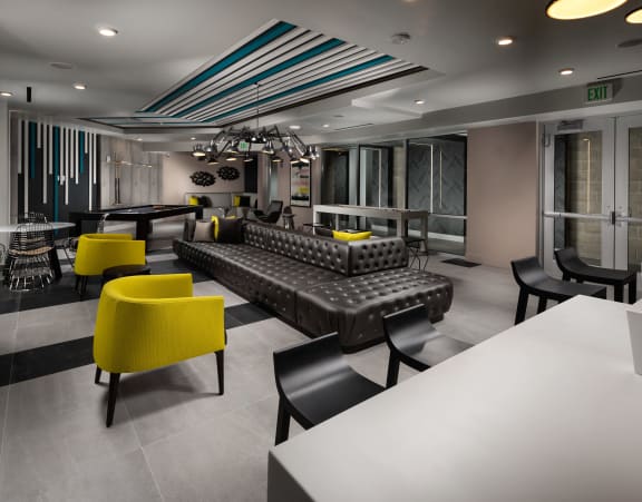 a lounge area with couches and chairs and a ping pong table
