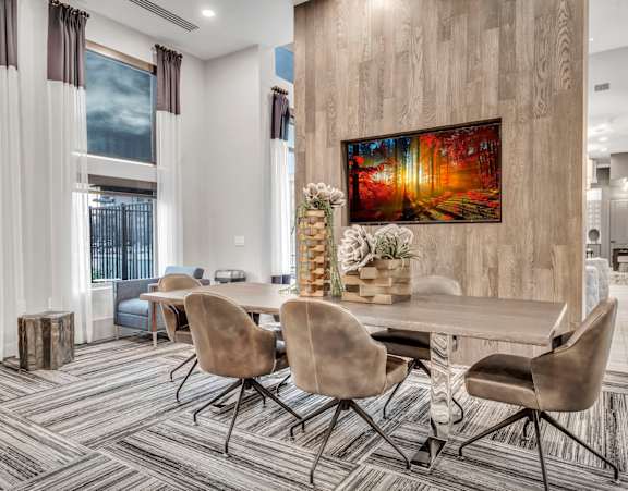 A conference room with a large painting on the wall and a long table with chairs.