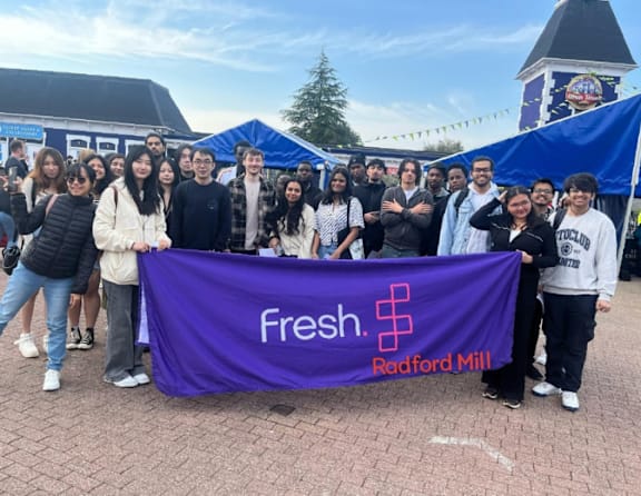 A group of people are holding a purple banner that says "Fresh. Radford Mill".