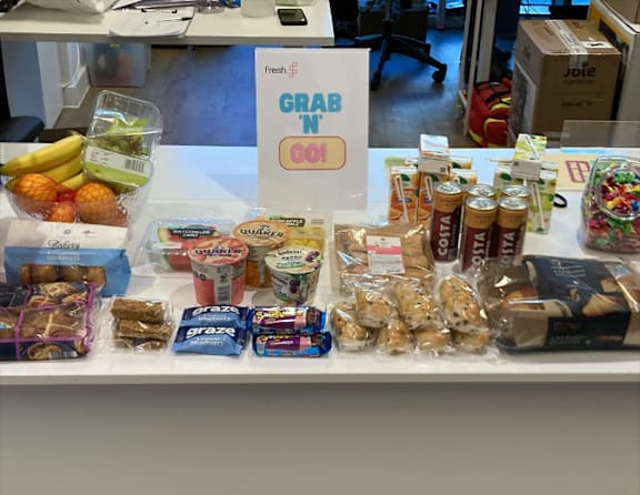 Packages of food items are stacked on a table.