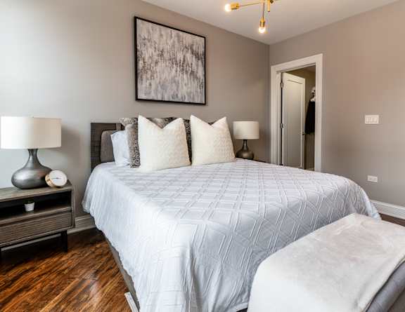 a bedroom with a large white bed and a closet