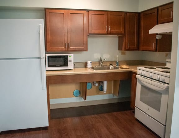 a kitchen with white appliances and wooden cabinets