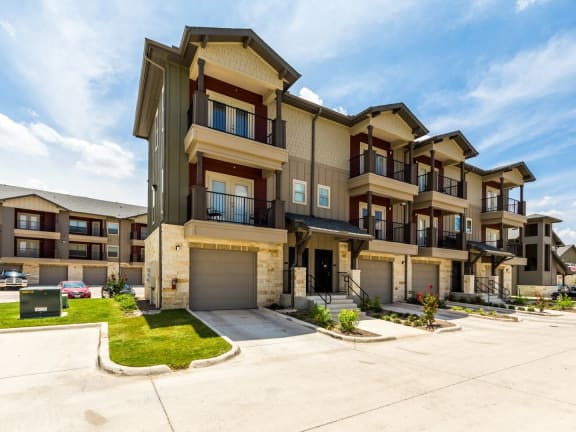 a row of apartment buildings with a blue sky in the background at Legacy Creekside Apartments, San Antonio, TX