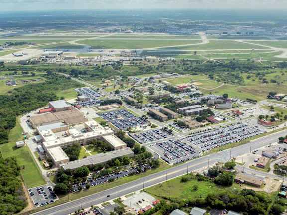 An aerial view of a parking lot, a building, and a runway.