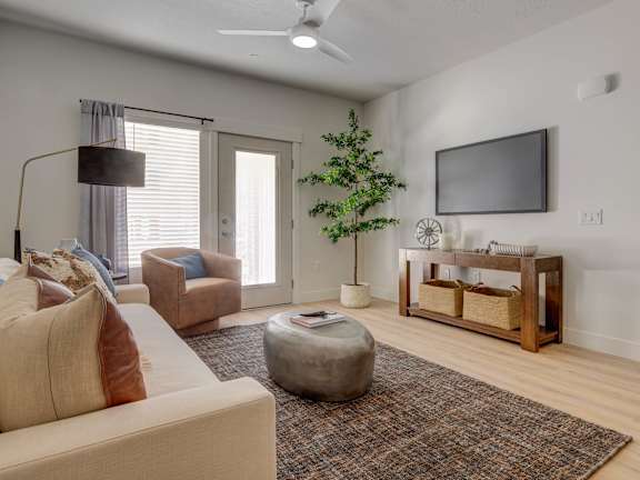A living room with a couch, chair, and a television.